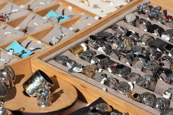 A jewelry stall at a flea market featuring a mix of fine and fashion jewelry.