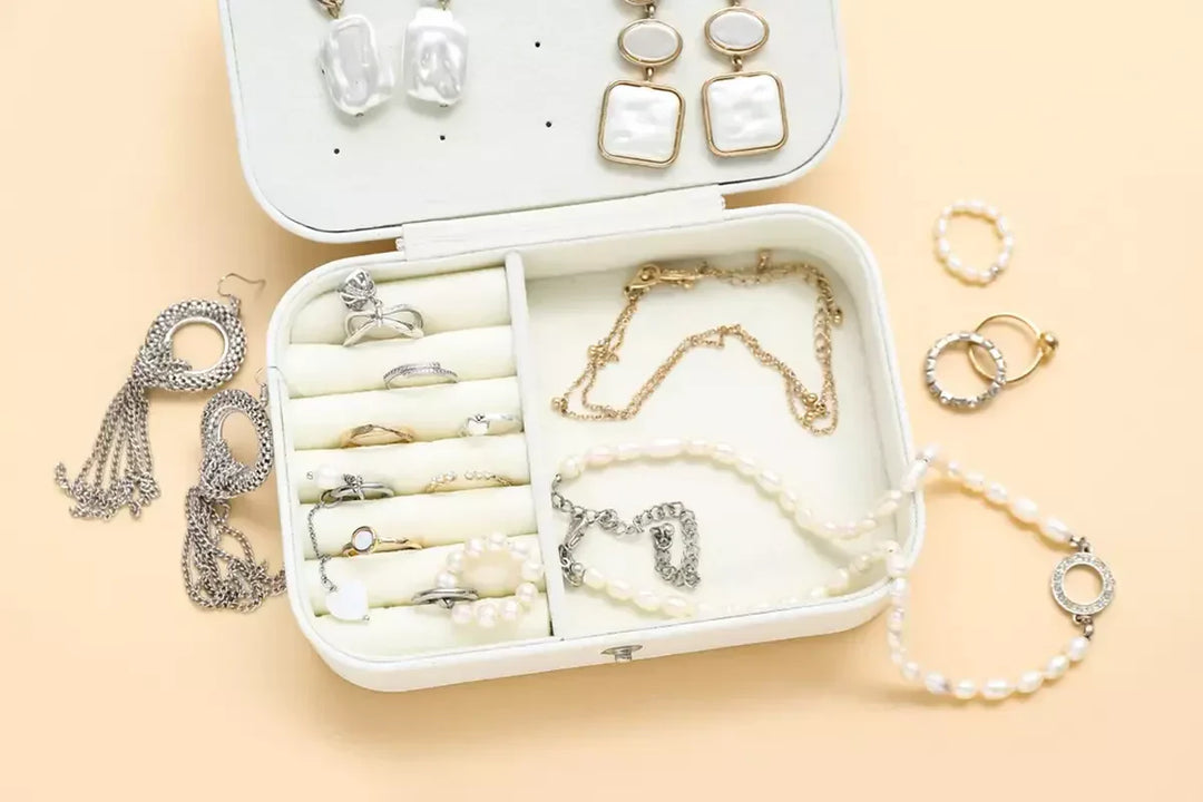Organizer with stylish jewelry on pale orange background