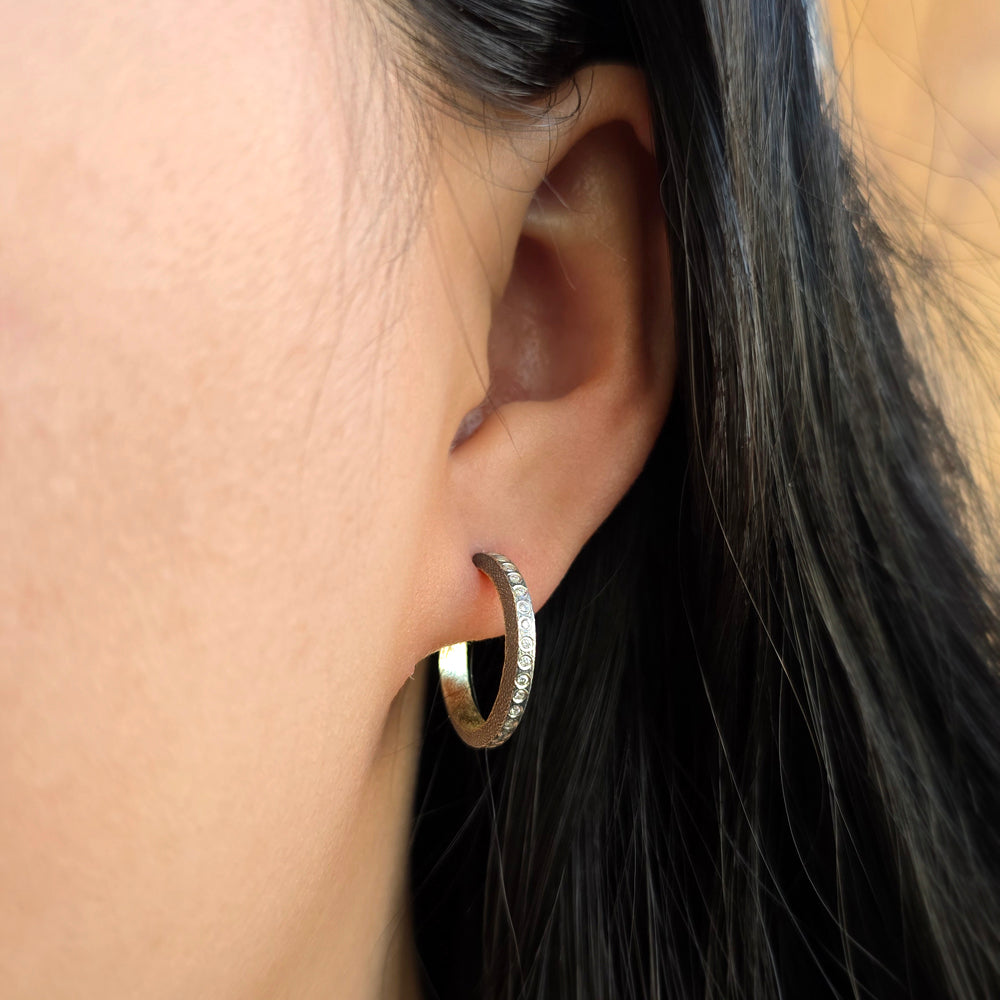 Woman wearing Adam diamond hoop earrings from Alara Jewelry