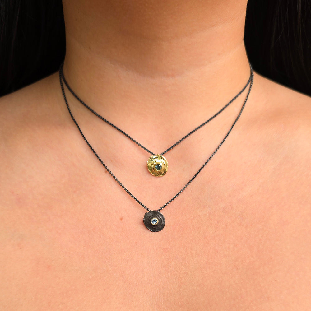 Woman wearing True Aim gold bullet pendant with Montana sapphire paired with another from Gold & Smoke