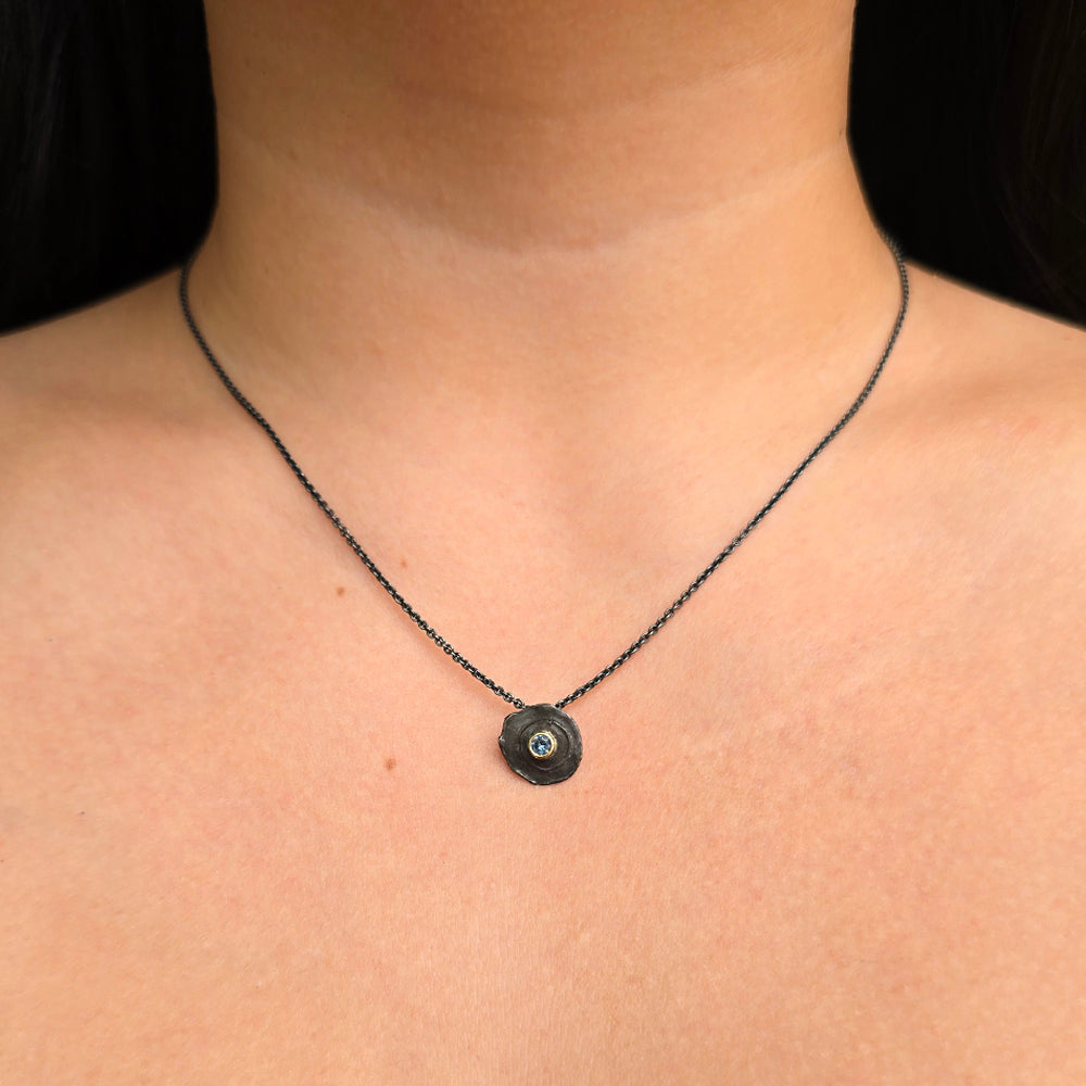 Woman wearing Centerfire Montana sapphire pendant in oxidized sterling silver 
