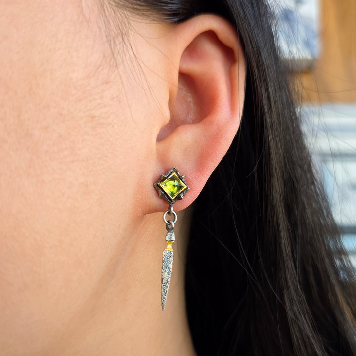 Woman wearing green tourmaline drop earrings with oxidized silver and gold accents from Alara Jewelry