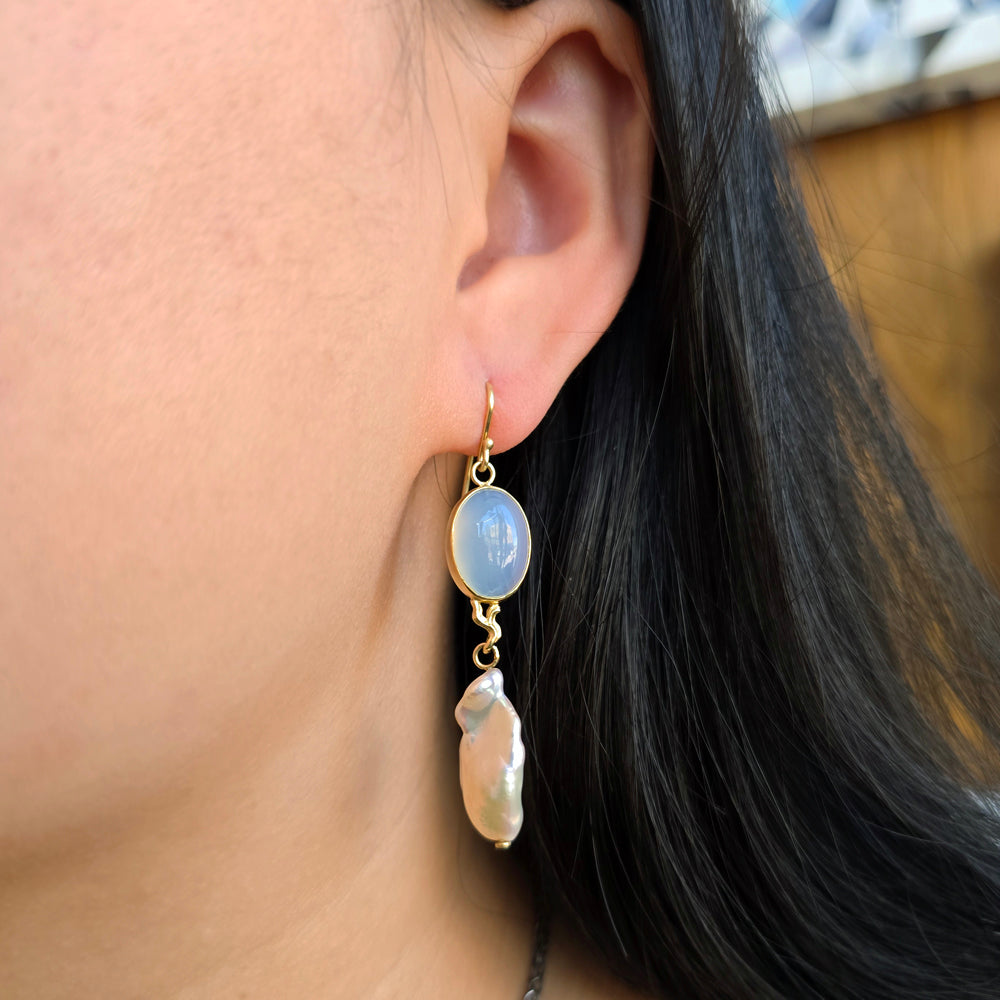 Woman wearing chalcedony and Keshi pearl drop earrings in 18K gold from Alara Jewelry