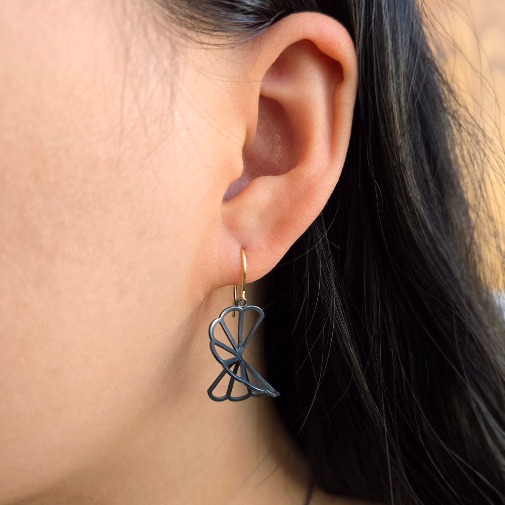 Woman wearing Nimbus cloud earrings in oxidized silver and gold from Alara Jewelry