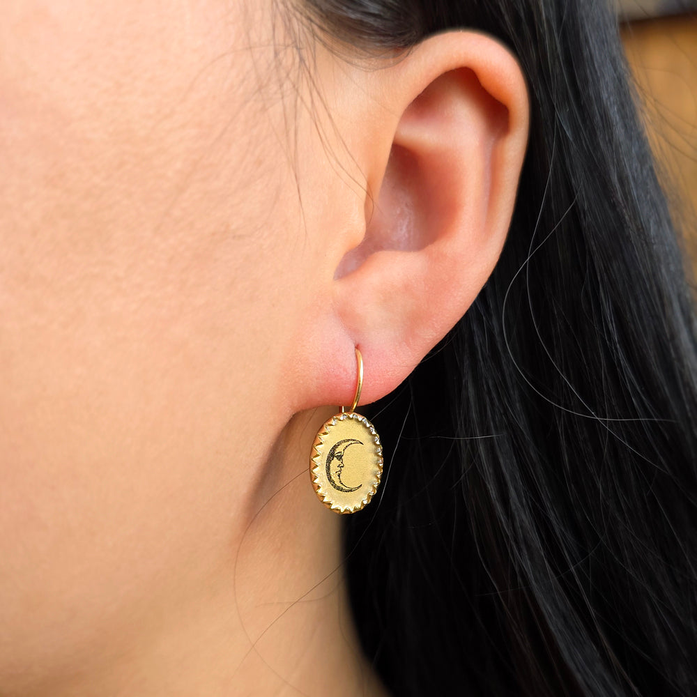 Woman wearing Day & Night sun and moon earrings from Alara Jewelry
