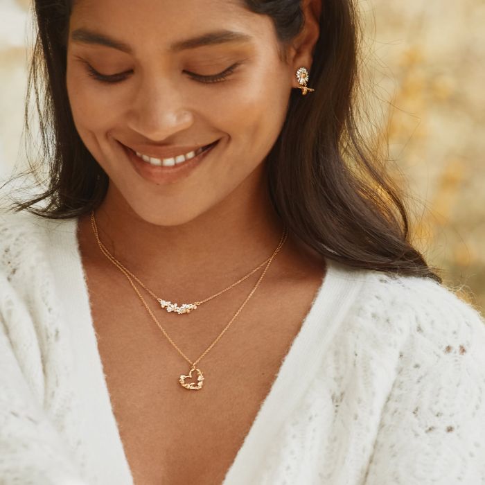 Woman wearing floral heart bee pendant necklace by Alex Monroe from Alara Jewelry