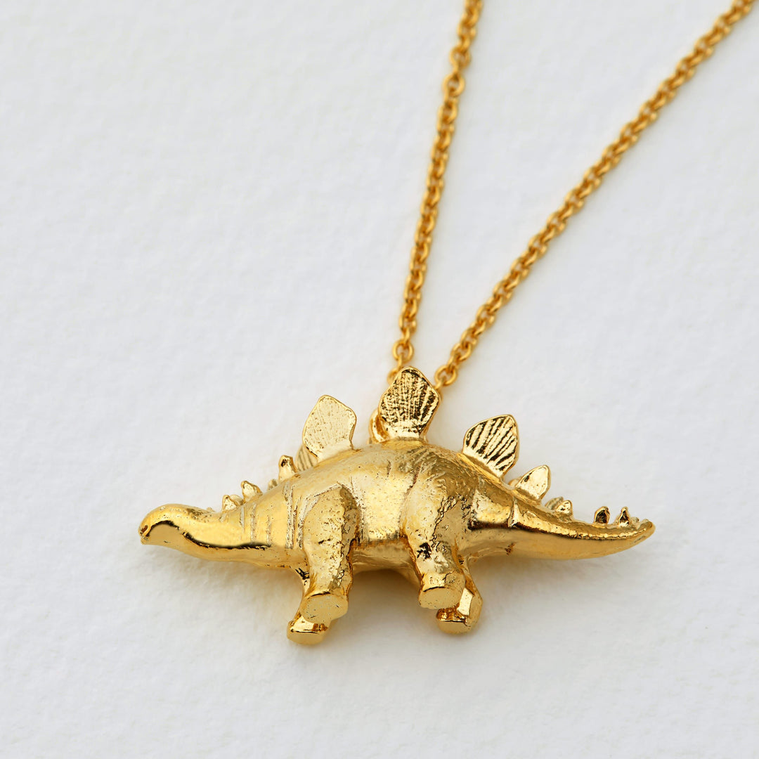 Close-up of detailed Stegosaurus pendant showing plated silhouette