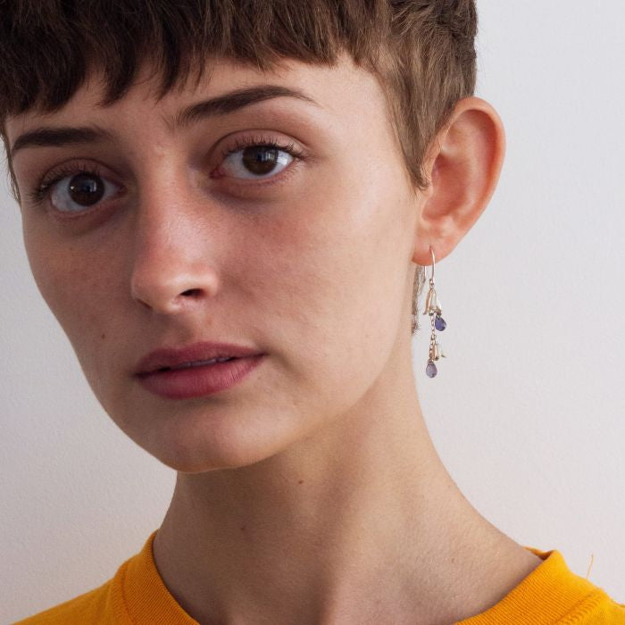 Woman wearing Bluebell iolite drop earrings by Alex Monroe from Alara Jewelry