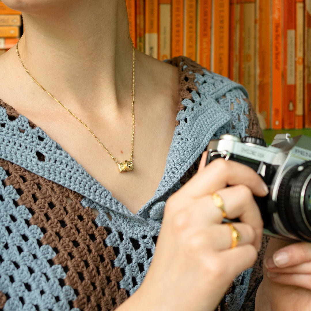 Woman wearing vintage camera pendant necklace by Alex Monroe from Alara Jewelry