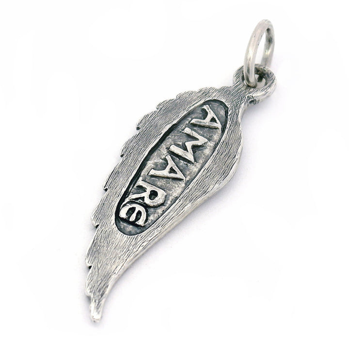 Silver pendant with 'AMARE' engraving on a white background