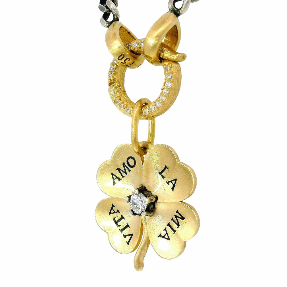 Close-up of engraved gold clover pendant with brushed satin finish