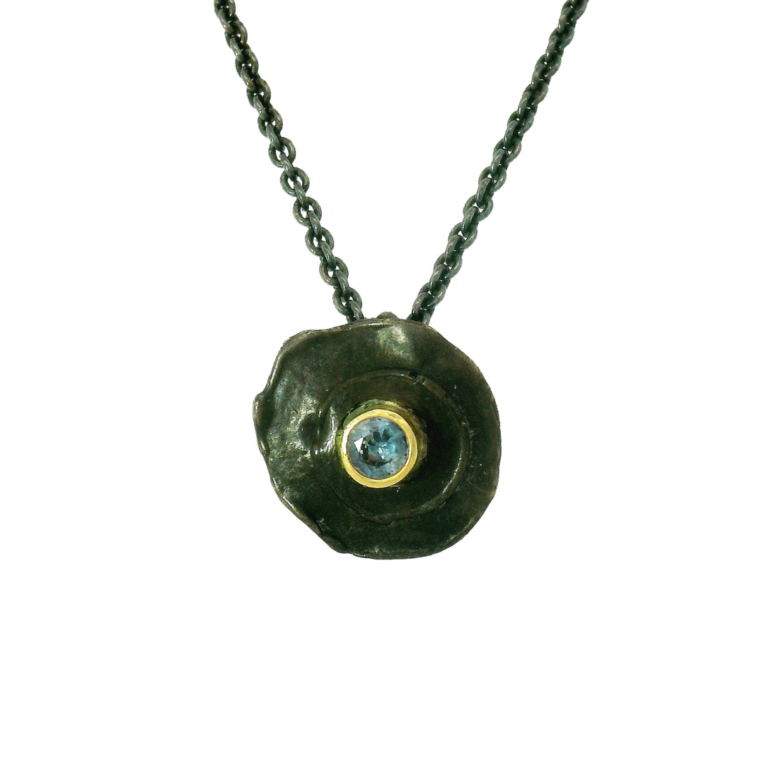 Bullet-inspired circular pendant with blue Montana sapphire center