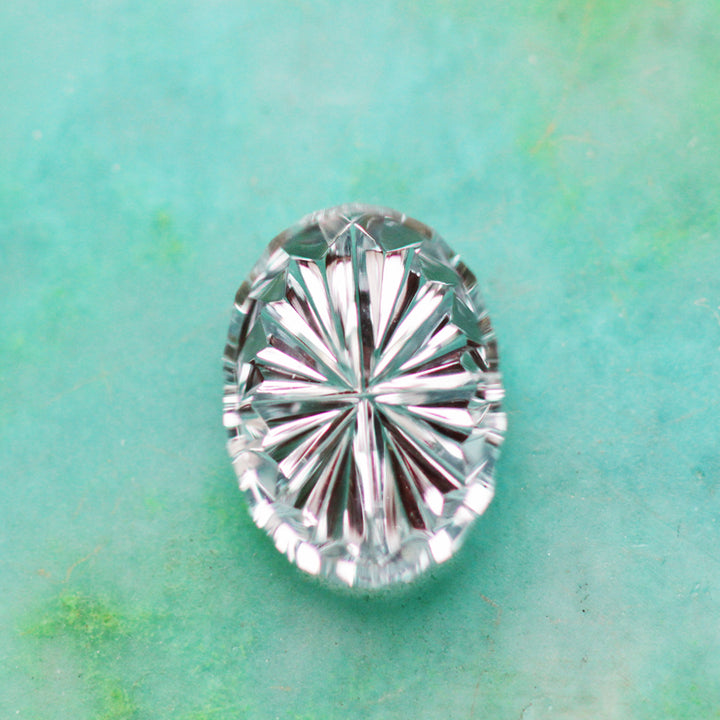 Light blue gemstone on a textured green background