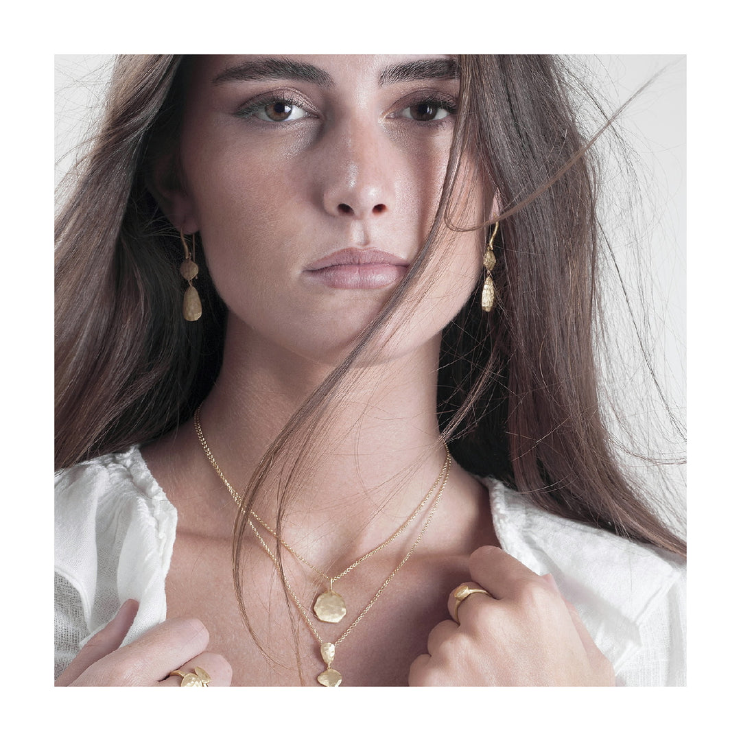 Woman wearing Essential Petal gold vermeil drop earrings by Jorge Revilla from Alara Jewelry