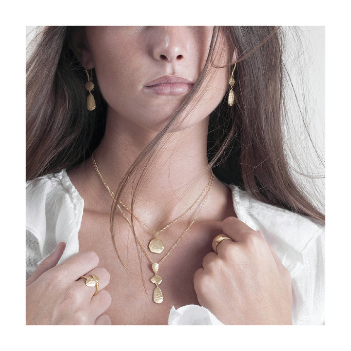 Woman wearing hammered gold vermeil drop necklace by Jorge Revilla from Alara Jewelry
