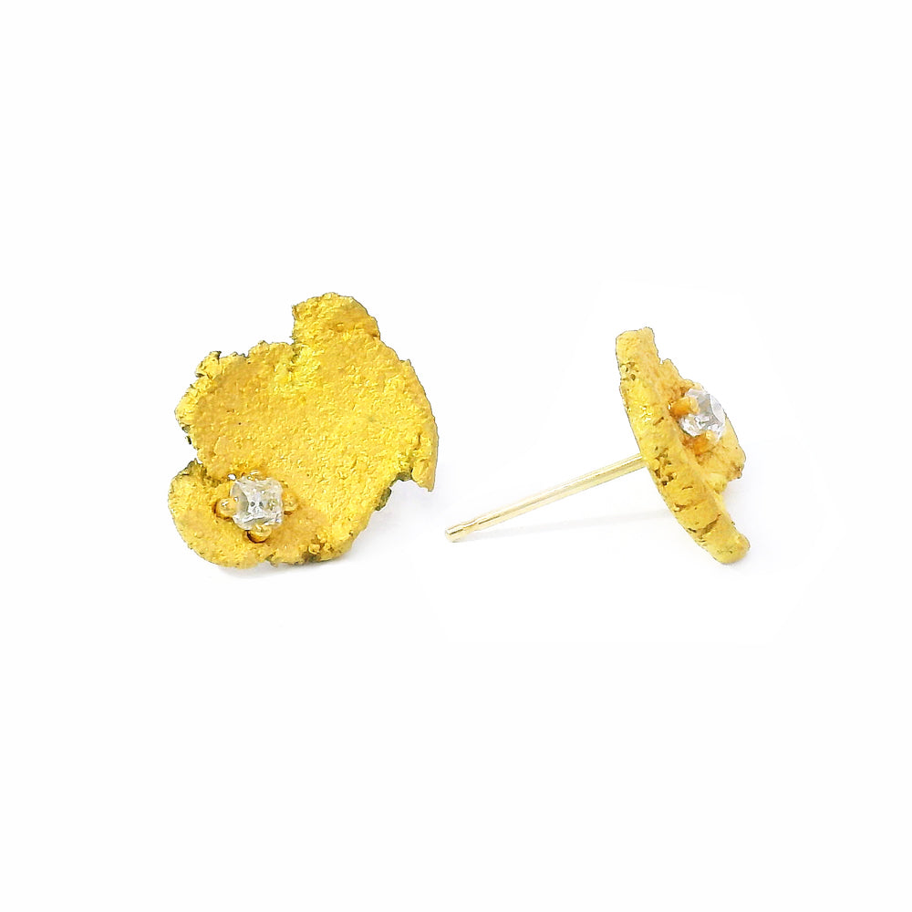 Close-up of asymmetrical 22K gold diamond stud earrings, handcrafted jewelry from Alara in Bozeman, Montana