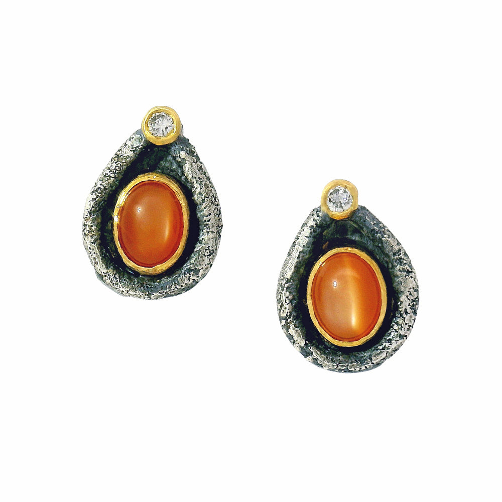 Peach cat-eye moonstone stud earrings with oxidized sterling silver and 22K gold bezels by Michael Jensen