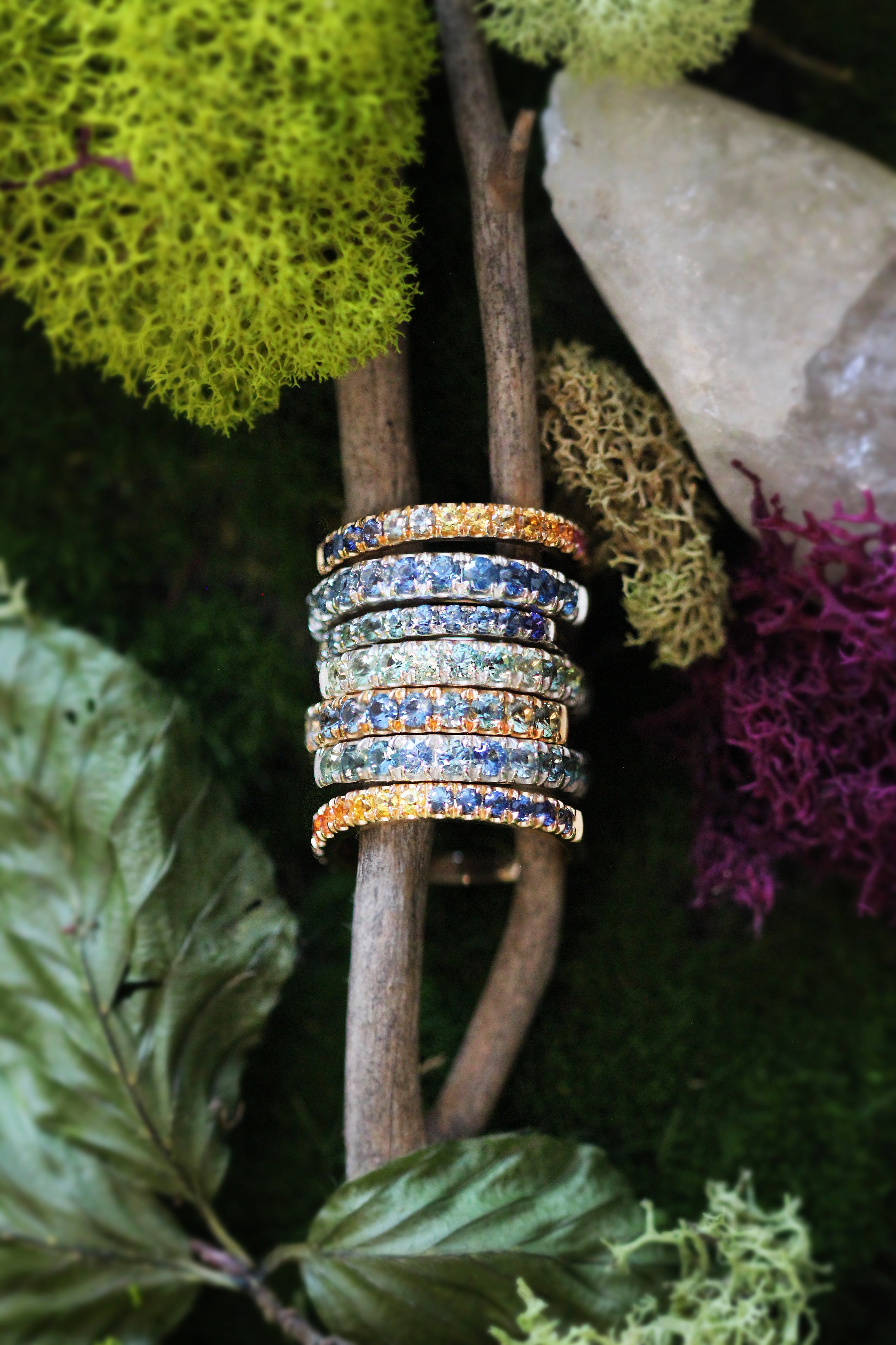 Stack of unique Montana Sapphire rings displayed in nature.