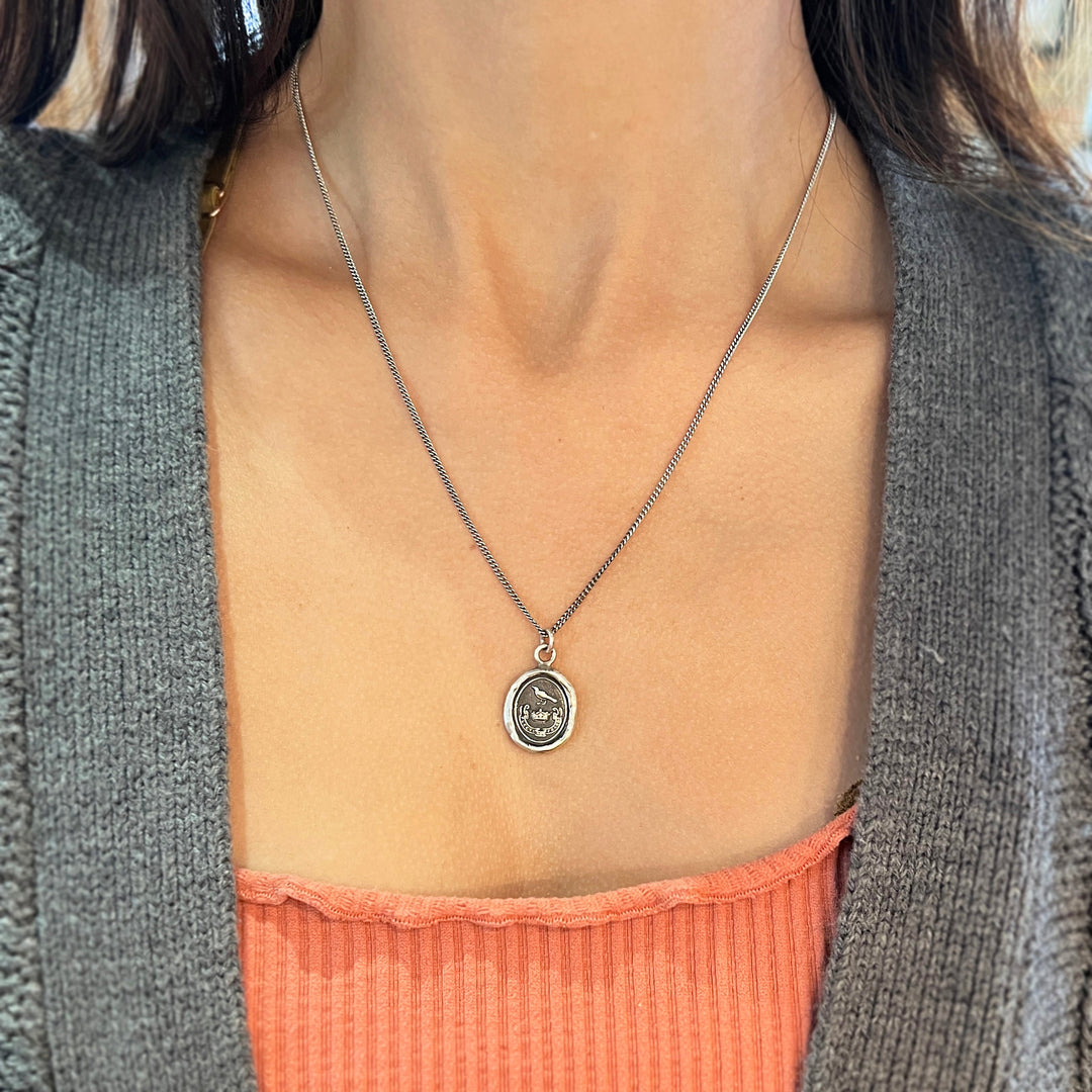 Woman wearing Unbreakable raven talisman necklace by Pyrrha from Alara Jewelry