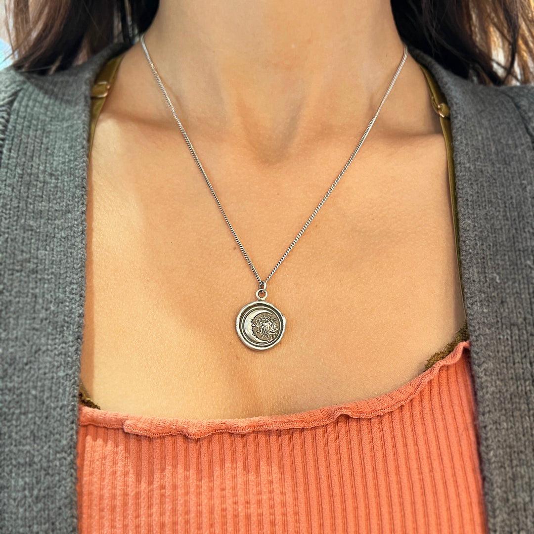 Woman wearing Trust the Universe celestial talisman necklace from Alara Jewelry