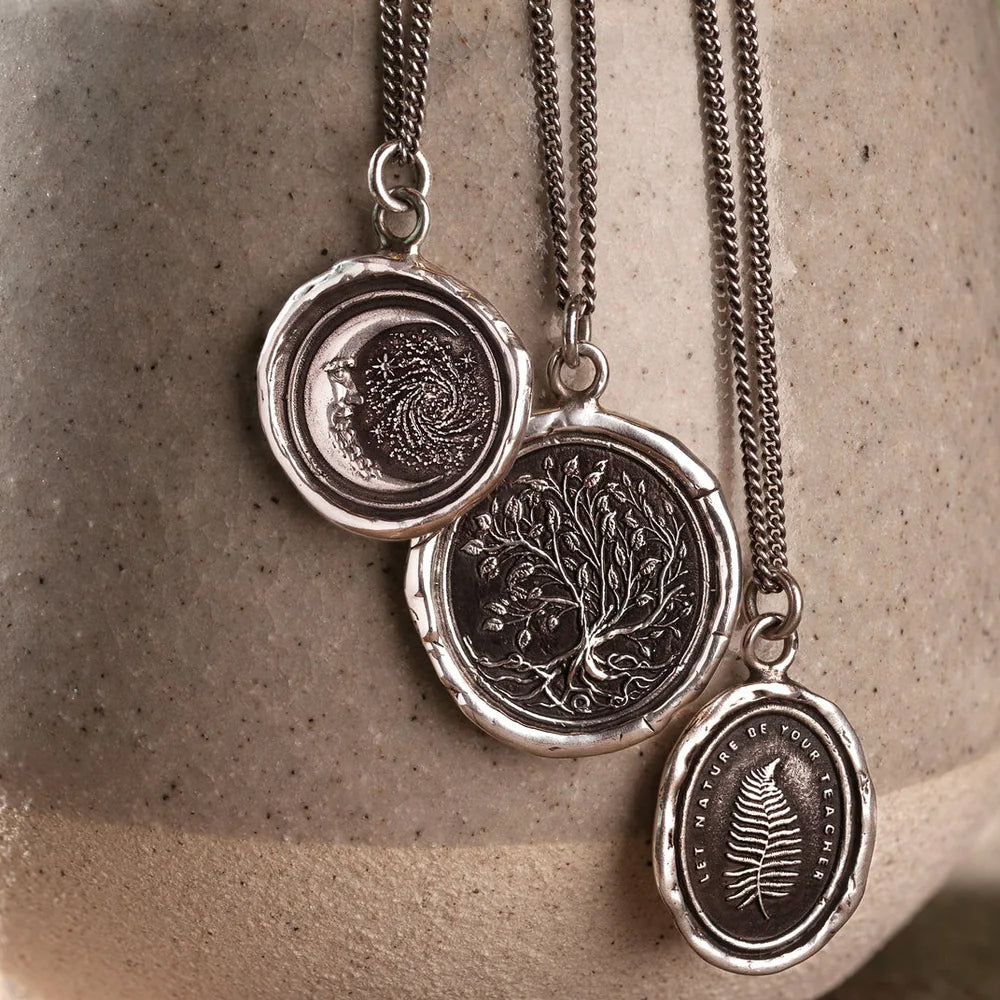 Close-up of tree of life design on antiqued sterling silver talisman