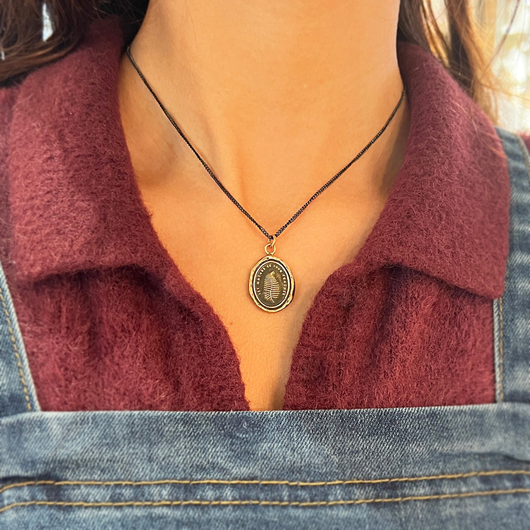 Woman wearing fern talisman necklace by Pyrrha from Alara Jewelry