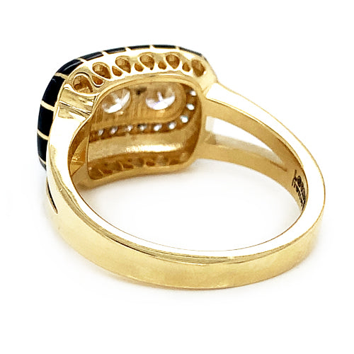 Back and underside  view of an 18k yellow gold ring with three larger center brilliant-cut diamonds surrounded by a halo of round diamonds and black enamel detailing.