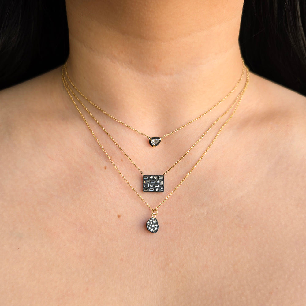 Woman wearing Meteor inverted diamond pendant necklace from Alara Jewelry